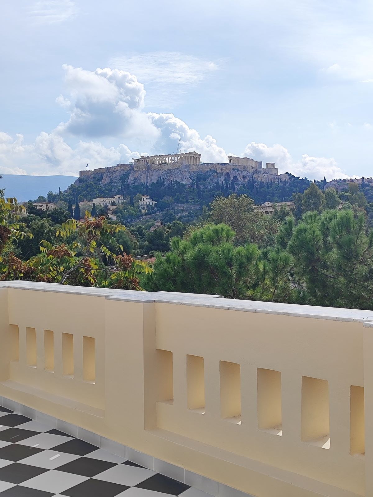 Η μεγάλη βεράντα με κτιστό στηθαίο με θέα προς την Πλάκα και την Ακρόπολη