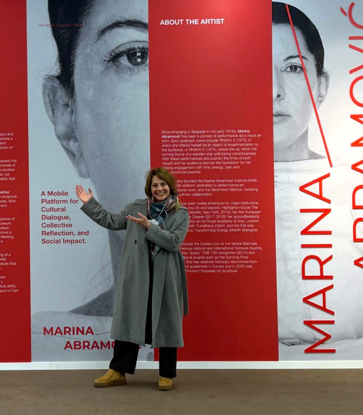 Η επιμελήτρια τέχνης Μιρτζάμ Βαραντίνις μπροστά στην αφίσα της Μαρίνας Αμπράμοβιτς