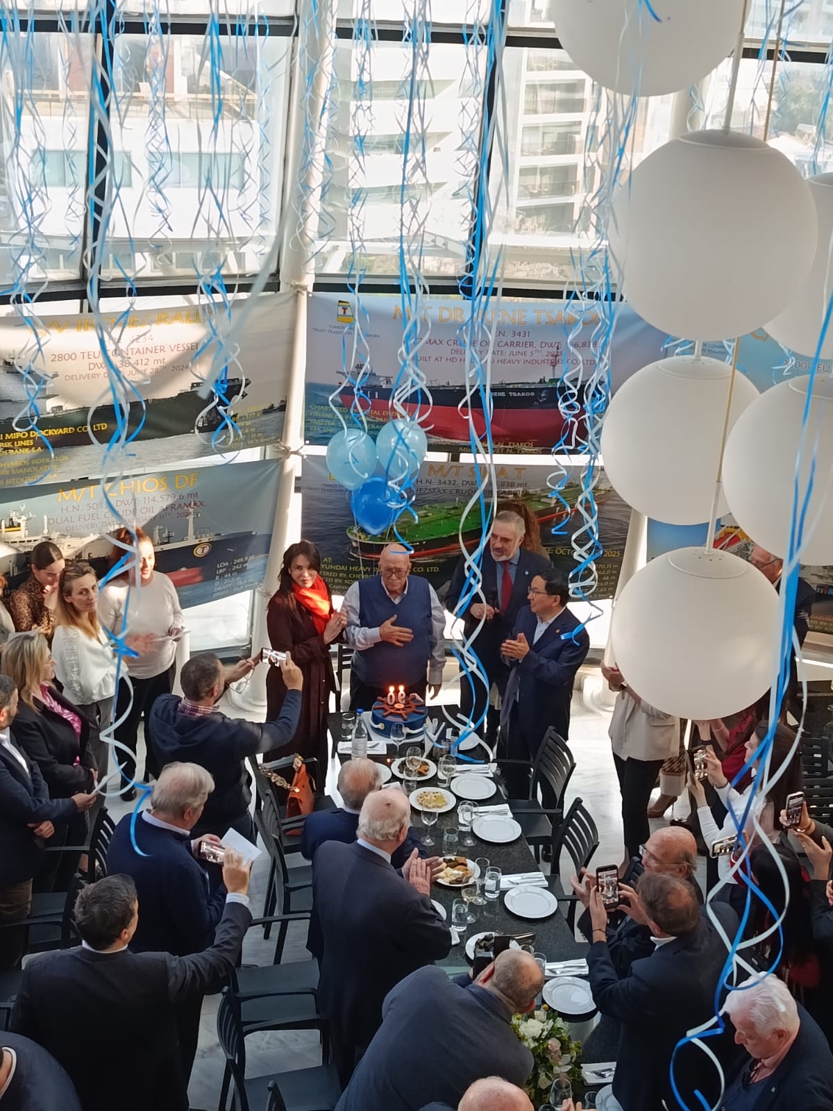 Ο Παναγιώτης Τσάκος, με την Σήλια Κριθαριώτη και τον Νίκο Τσάκο στο πλευρό του, γιορτάζει με το προσωπικό του ομίλου τα 90ά του γεννέθλια