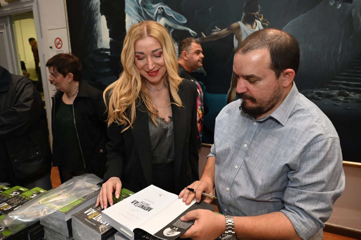 Ο Νίκος Μποζιονέλος υπογράφει το αντίτυπο της Ζέτας Θεοδωρακοπούλου